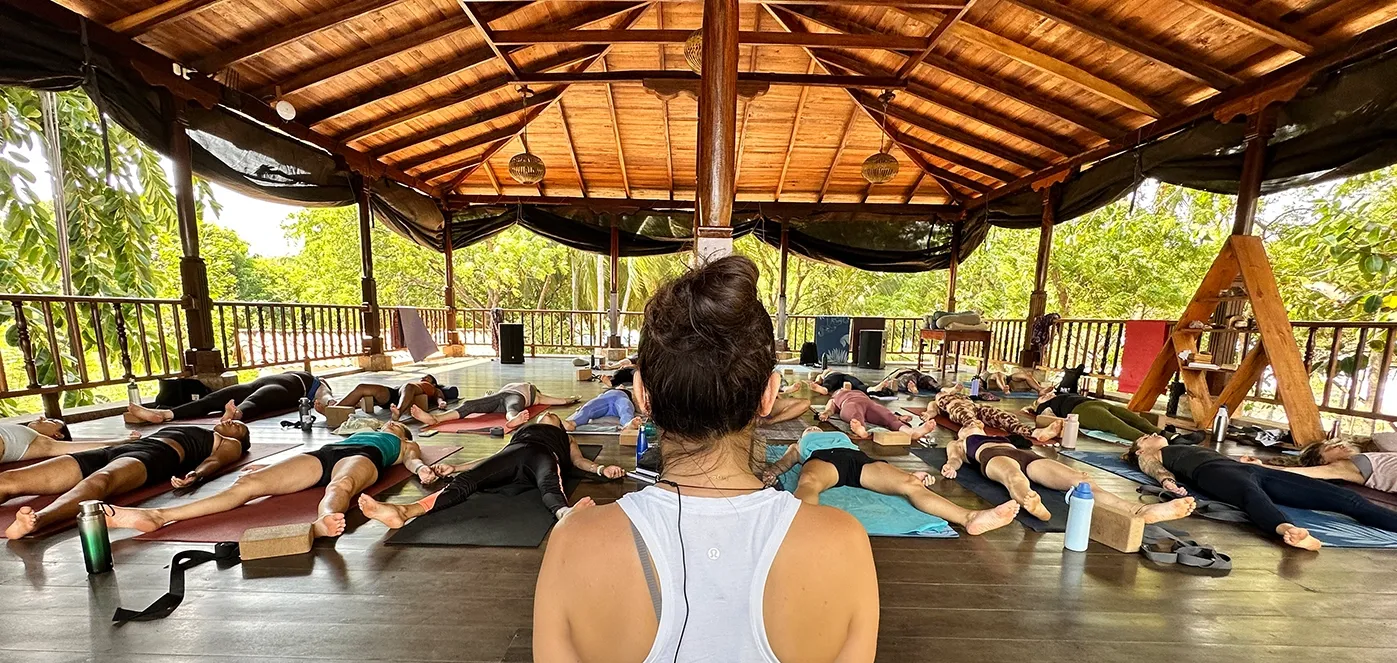Power Yoga Canada 200-hour Yoga Teacher Training students in Savasana during a guided meditation and relaxation practice at an immersive yoga retreat.